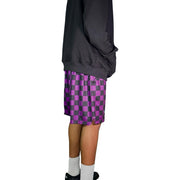 Person wearing a dark hoodie and purple checkered shorts 