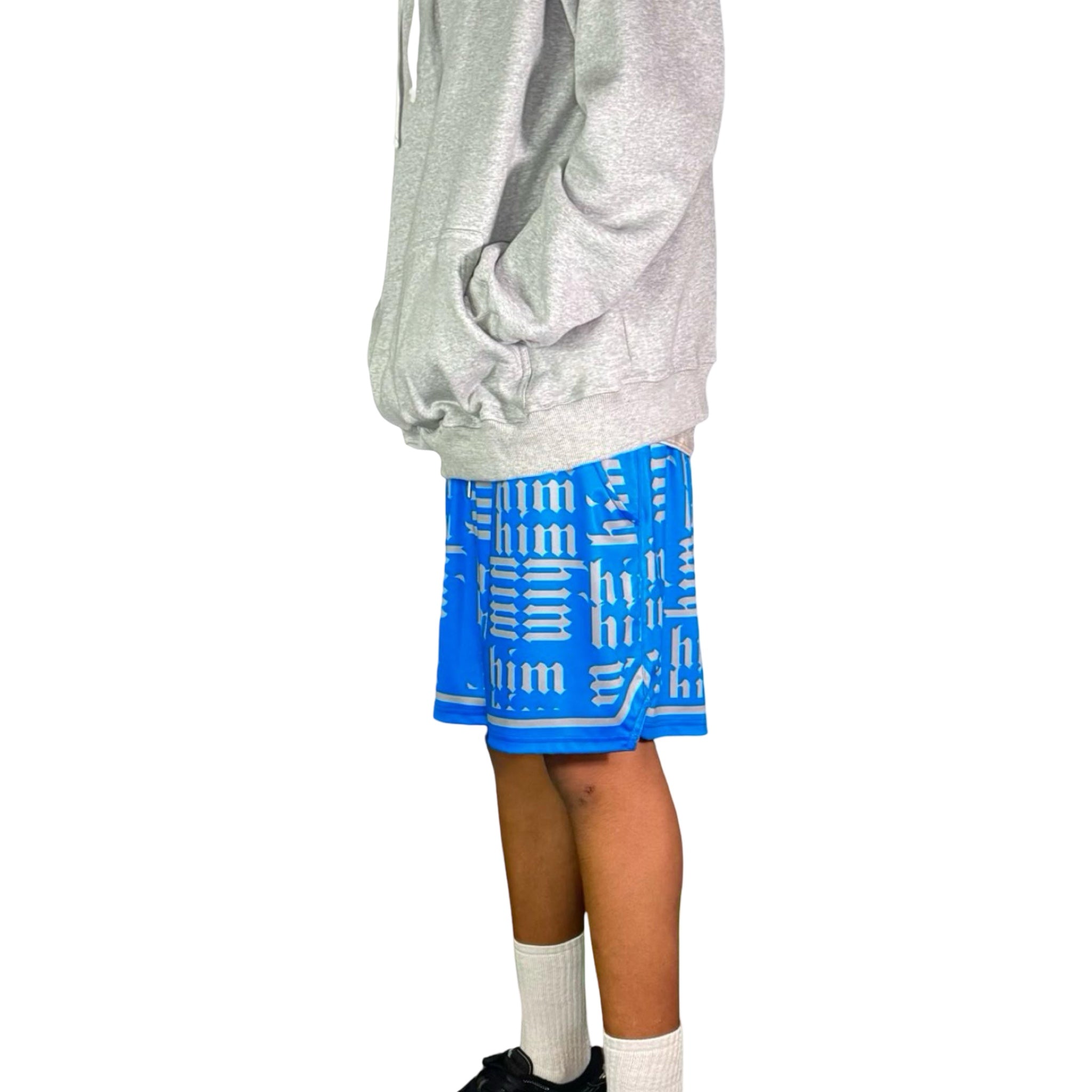 Person wearing a gray hoodie and blue shorts with silver text on a white background