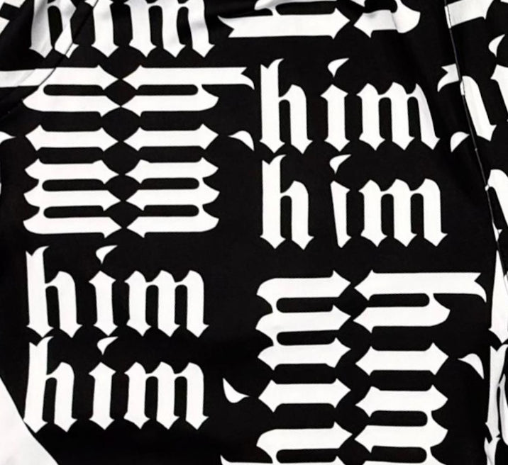 Closeup texture view of Panda black soft dry fit shorts with white him text repeating pattern on a white background
