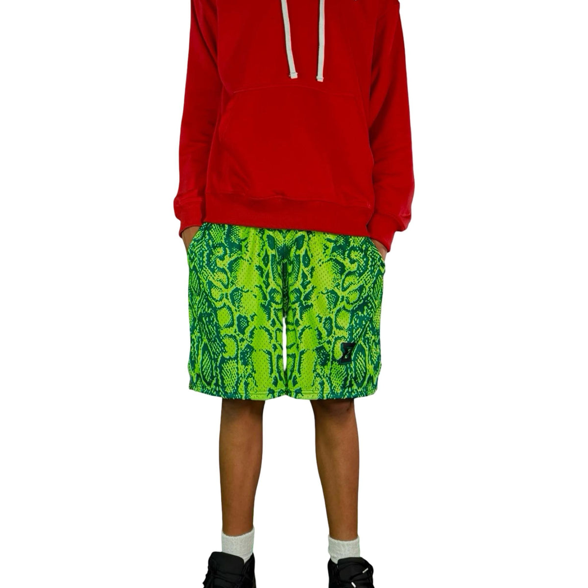 Person wearing a red hoodie and neon green snake patterned mesh shorts