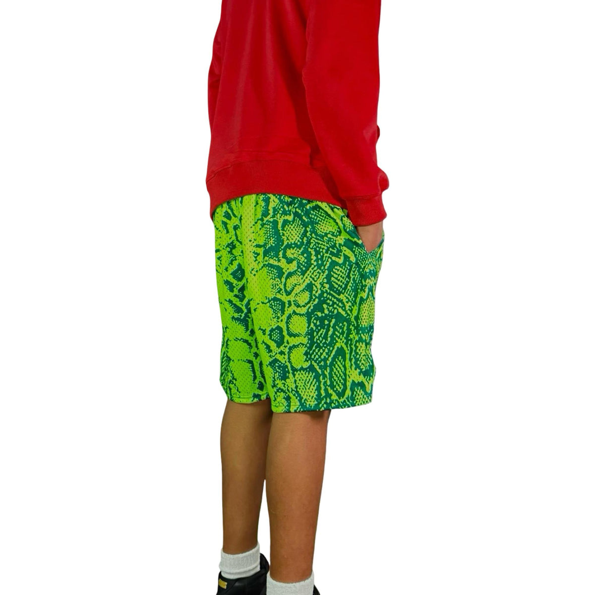 Person wearing a red hoodie and neon green snake patterned mesh shorts