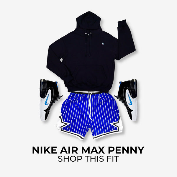Black hoodie, blue striped shorts, and black and white sneakers on a light gray background with 'Nike Air Max Penny' text.