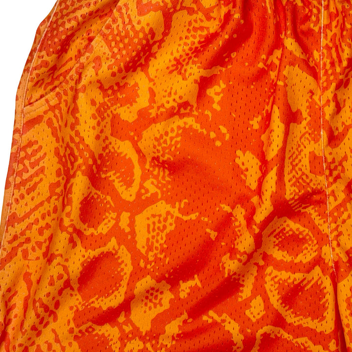 Neon orange snakeskin pattern mesh shorts texture close up