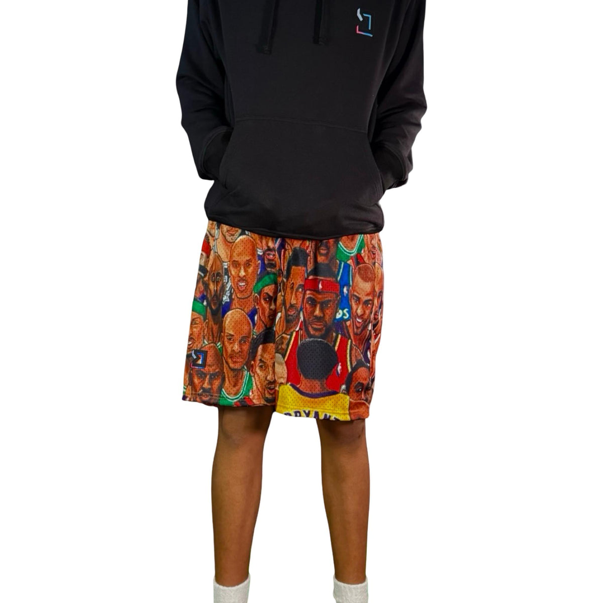 Person wearing a black hoodie and colorful shorts with graphic designs on a white background