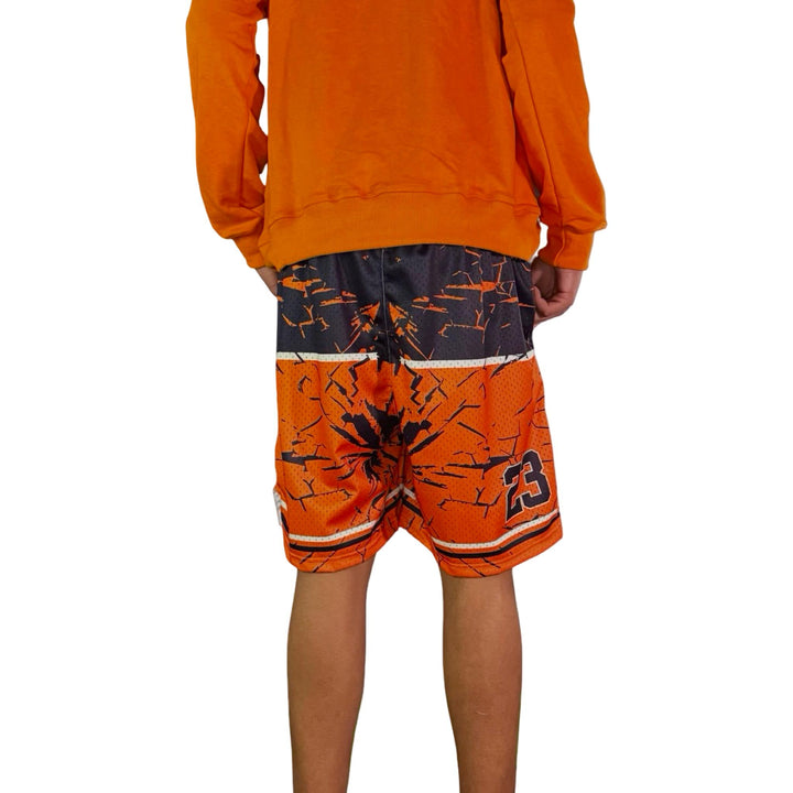 Orange athletic outfit with black and white patterned shorts on a white background