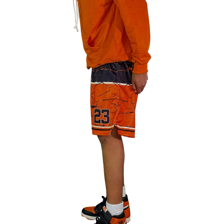 Person wearing orange shorts with number 23 on a white background