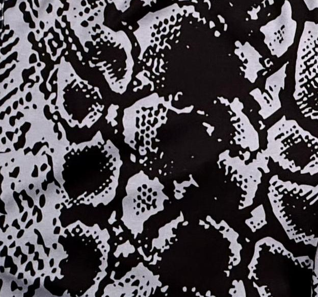 Closeup texture view of Black soft dry fit basketball shorts with silver snakeskin pattern on white background.