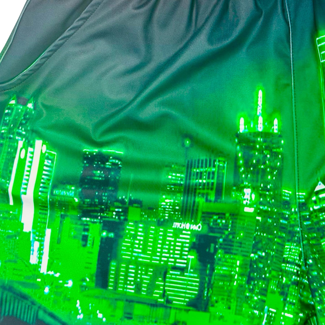 Close up texture view of Skyline green dry fit shorts with skyline graphic on white background.