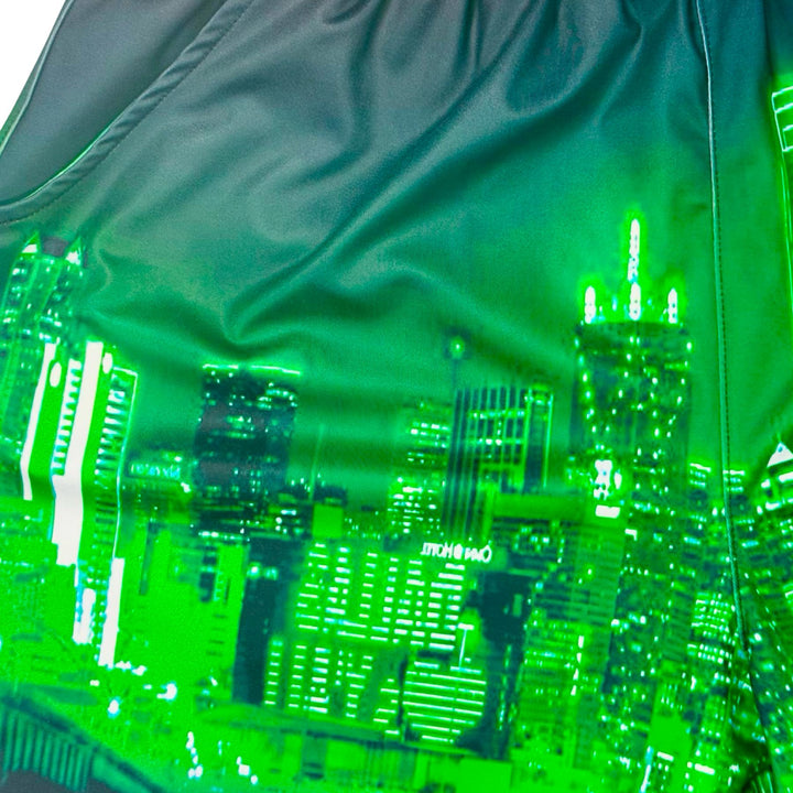 Close up texture view of Skyline green dry fit shorts with skyline graphic on white background.