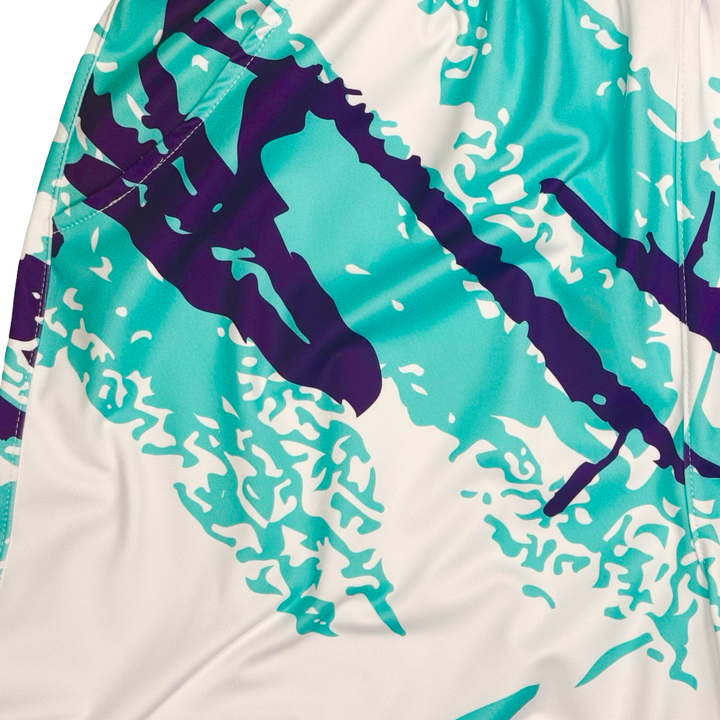 Close-up of a sports shorts with purple and teal designs on a white background