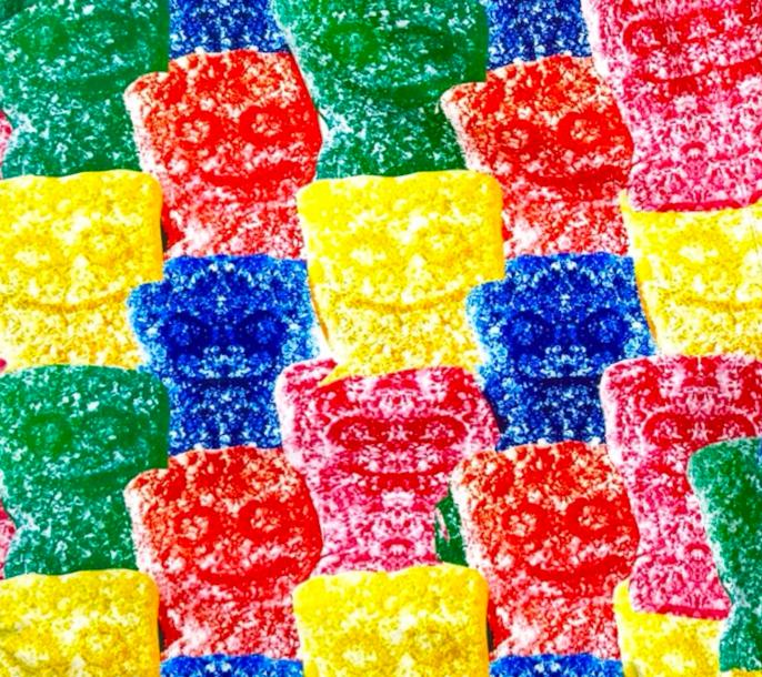 Closeup texture view of Multicolored soft dry fit basketball shorts with repeating Sour Candy graphic on a white background
