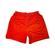Back side view of Red soft dry fit basketball shorts with black speckle repeating pattern on a white background