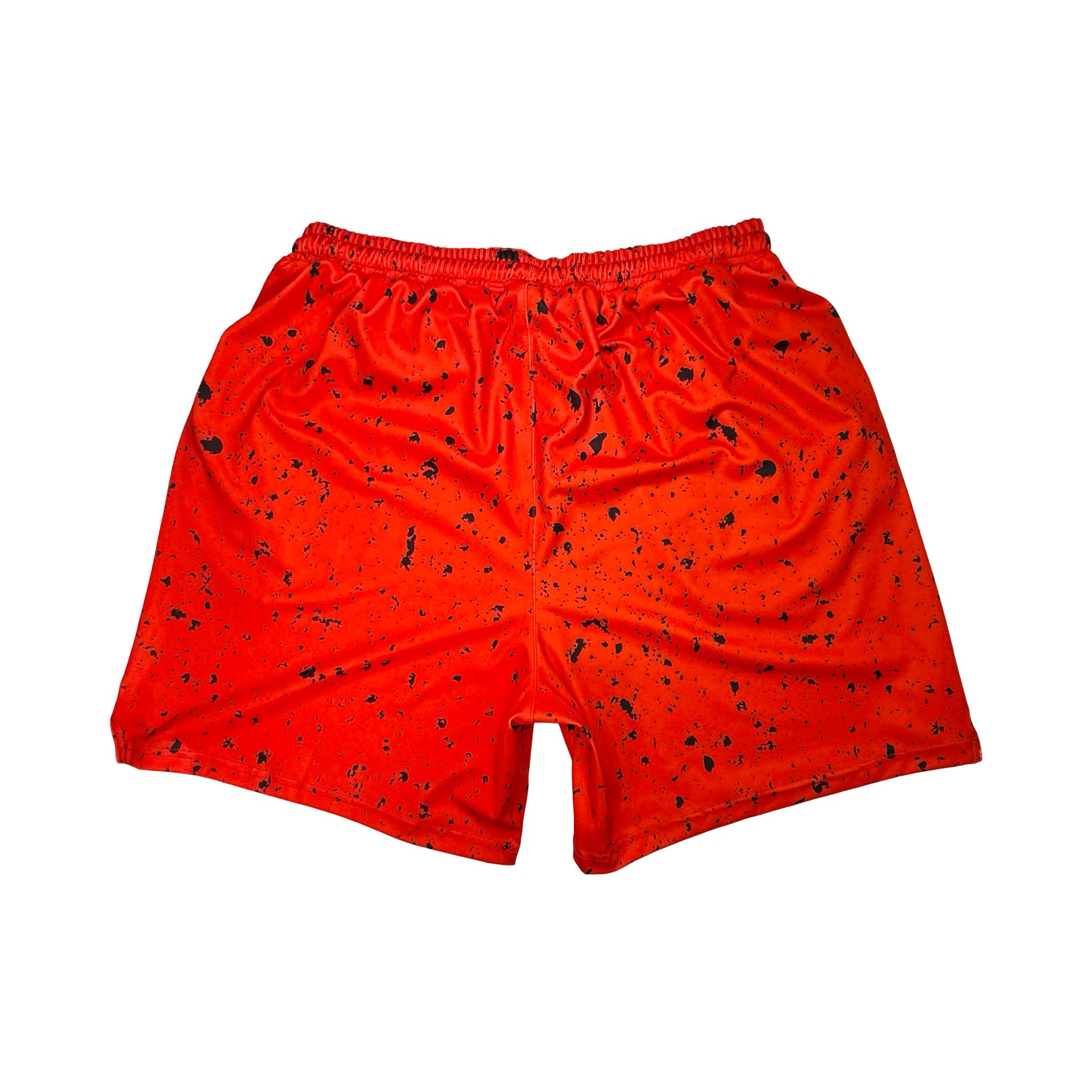 Back side view of Red soft dry fit basketball shorts with black speckle repeating pattern on a white background