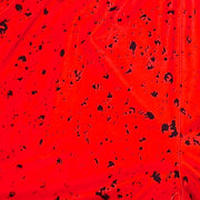 Closeup texture view of Red soft dry fit basketball shorts with black speckle repeating pattern on a white background