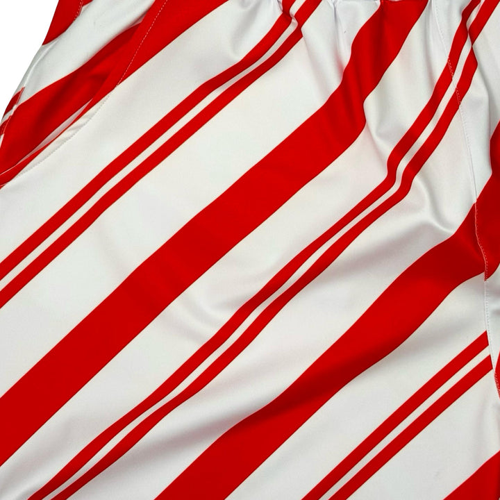 Closeup texture view of White dry fit shorts with red Candy cane striped pattern on white background.