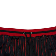 Close-up of a black mesh athletic skirt with red pinstripes and a red waistband featuring a black stripe and drawstring.