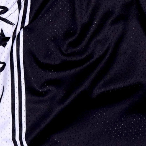 Close-up of black textured fabric with a white and black patterned background