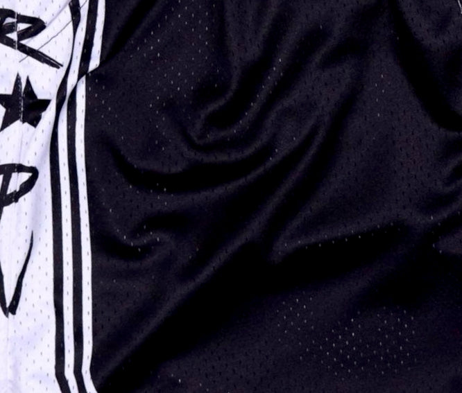Close-up of black textured fabric with a white and black patterned background