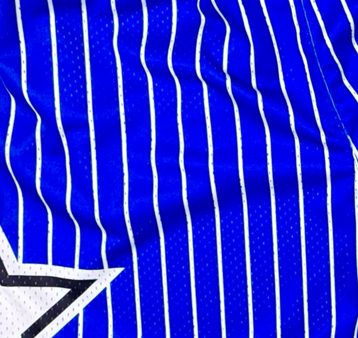 Closeup view of texture of Blue Pro style heavy duty white pinstripe mesh basketball shorts on a white background