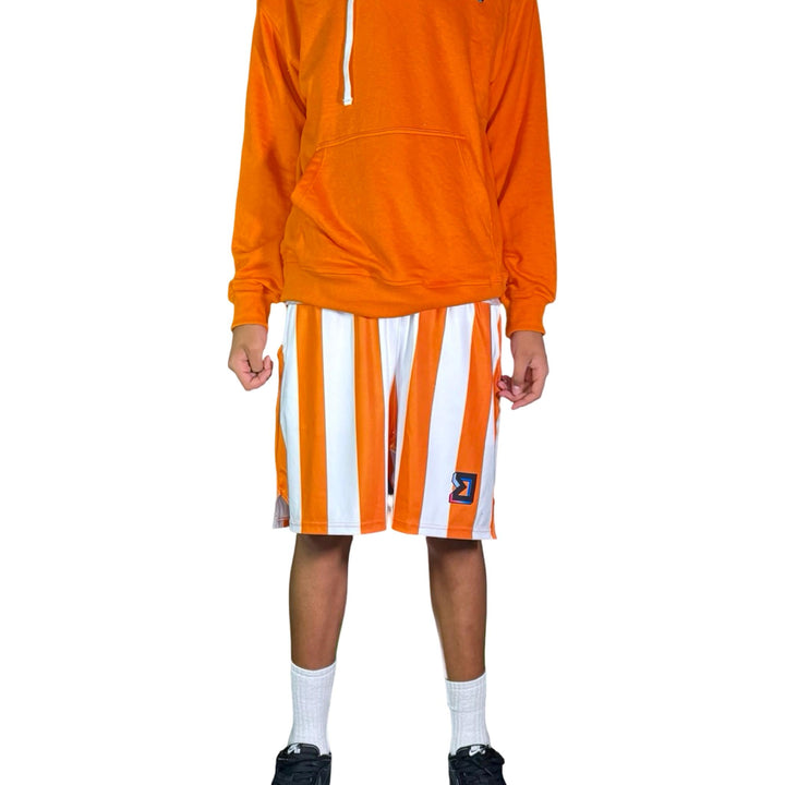 Person wearing an orange hoodie and striped shorts on a white background