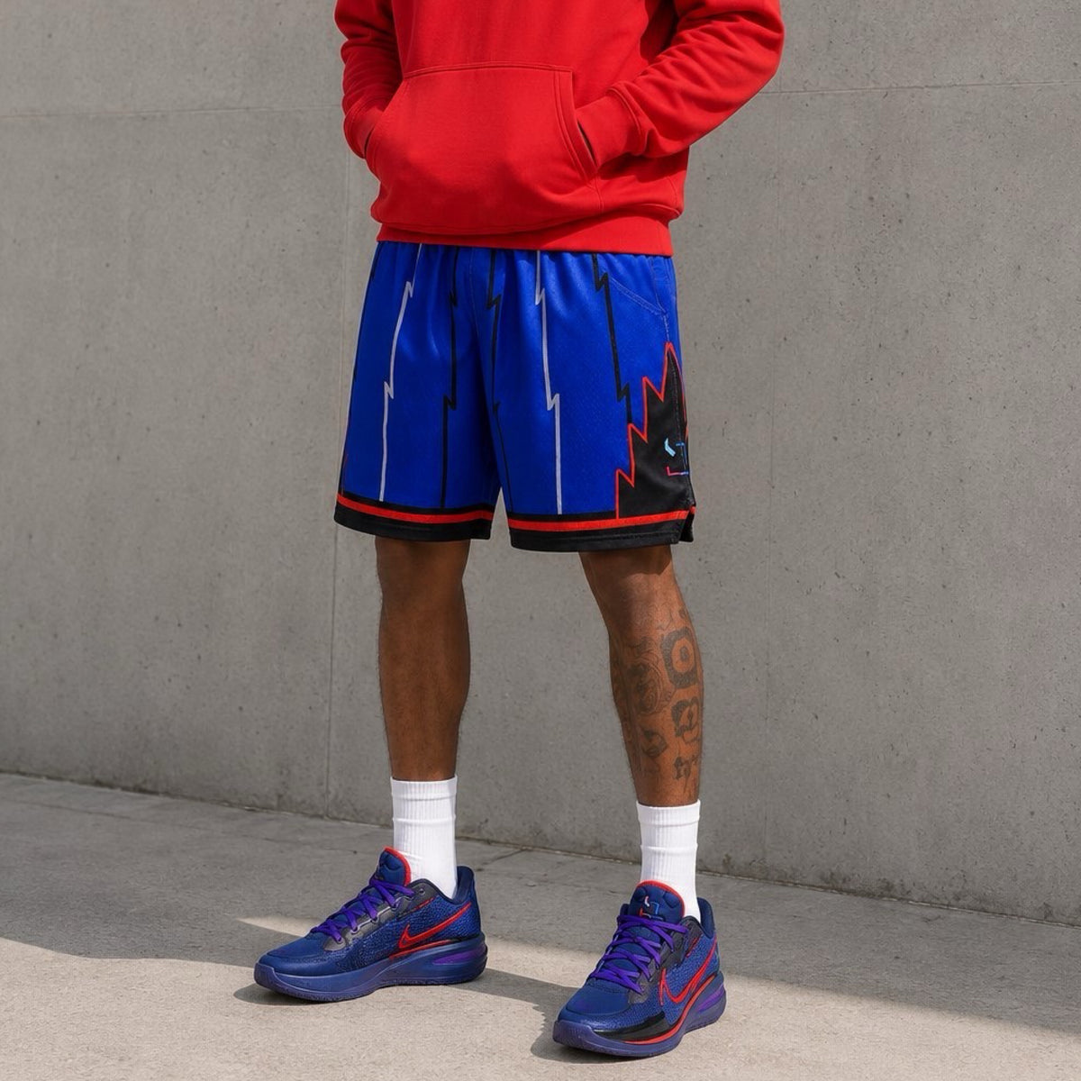 model wearing Purple mesh elite professional basketball shorts with 2 inch red and black waistband, multiple colored stripes on concrete background