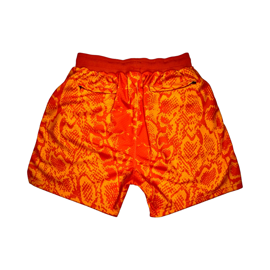 Mamba Elite PRO™ orange basketball shorts featuring a bold snakeskin-inspired pattern, premium MeshX™ construction, oversized PRO waistband, and performance athletic fit designed to match Kobe and Jordan sneakers.