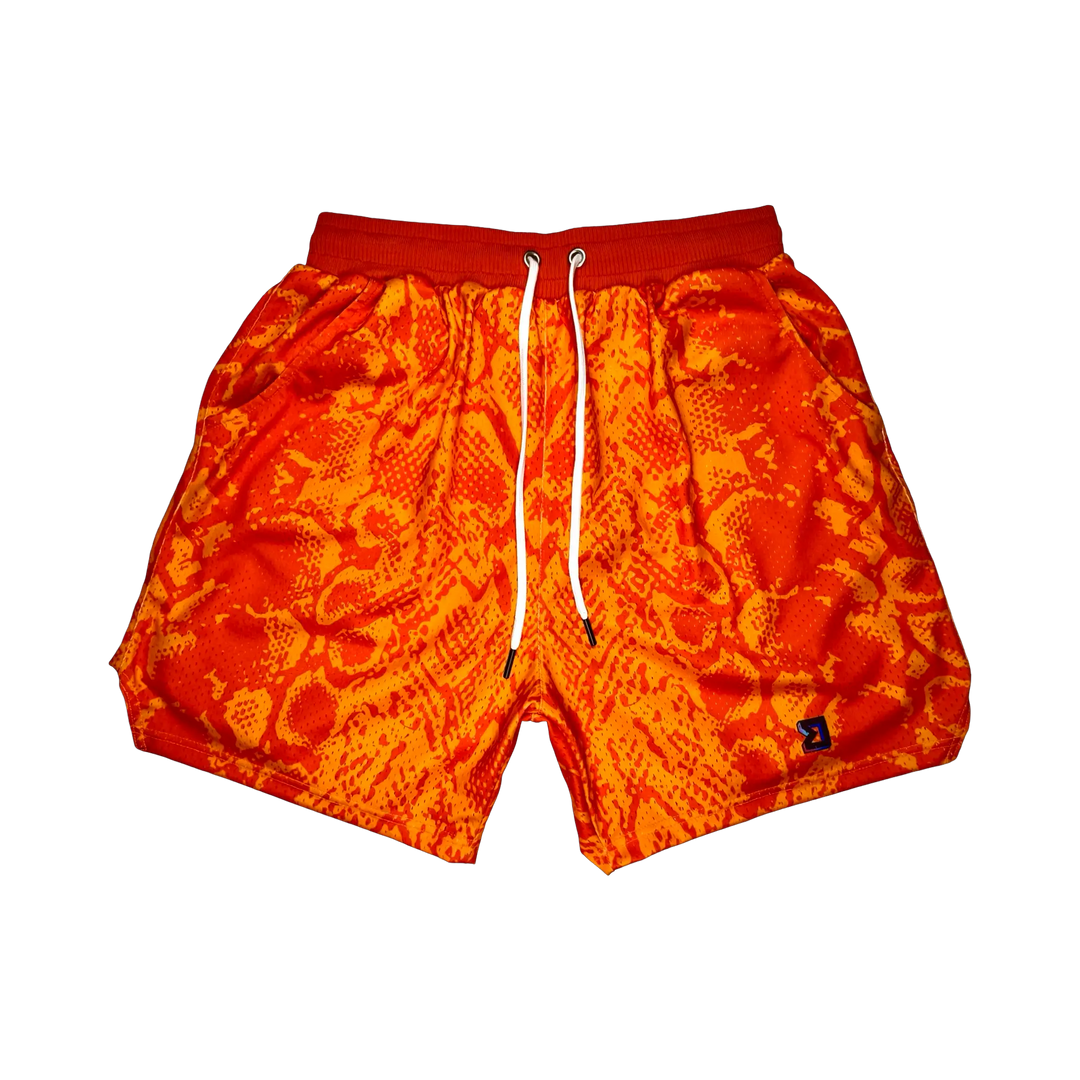 Mamba Elite PRO™ orange basketball shorts featuring a bold snakeskin-inspired pattern, premium MeshX™ construction, oversized PRO waistband, and performance athletic fit designed to match Kobe and Jordan sneakers.