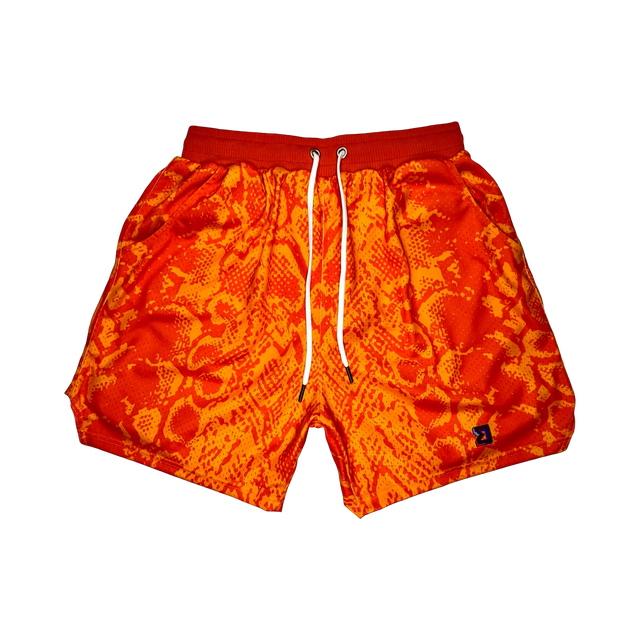 Mamba Elite PRO™ orange basketball shorts featuring a bold snakeskin-inspired pattern, premium MeshX™ construction, oversized PRO waistband, and performance athletic fit designed to match Kobe and Jordan sneakers.