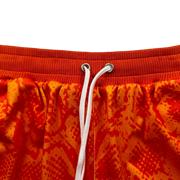 Mamba Elite PRO™ orange basketball shorts featuring a bold snakeskin-inspired pattern, premium MeshX™ construction, oversized PRO waistband, and performance athletic fit designed to match Kobe and Jordan sneakers.