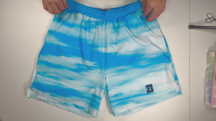 Clouds GO basketball shorts with a blue sky pattern. Lightweight, breathable, water-resistant GO fabric. Above-knee fit by Trap’N Shorts.