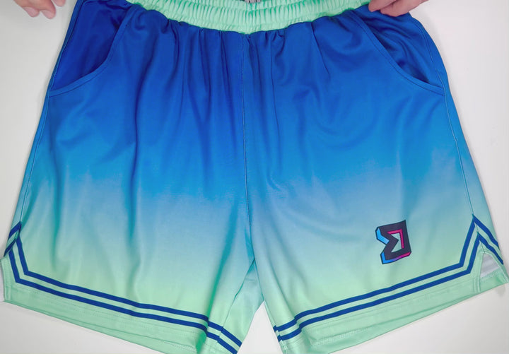 Tech Soft Quick-Dry basketball shorts with blue-to-mint gradient fade and minimalist line detailing by Trap’N Shorts.