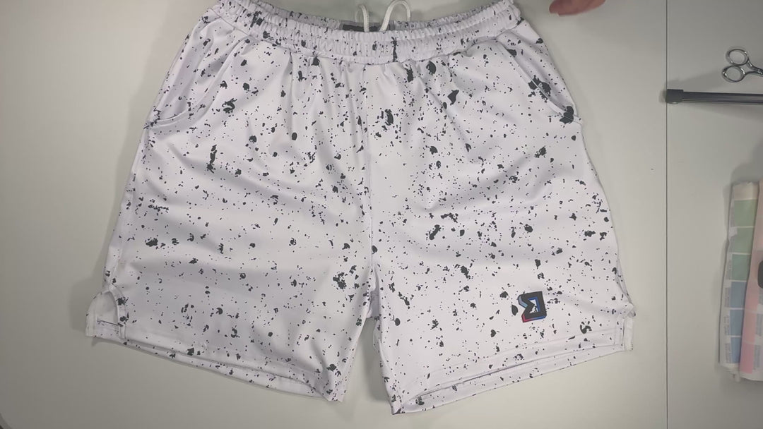 Speckle Soft QD basketball shorts with white/black splatter design. Lightweight, smooth, moisture-wicking  by Trap’N Shorts.