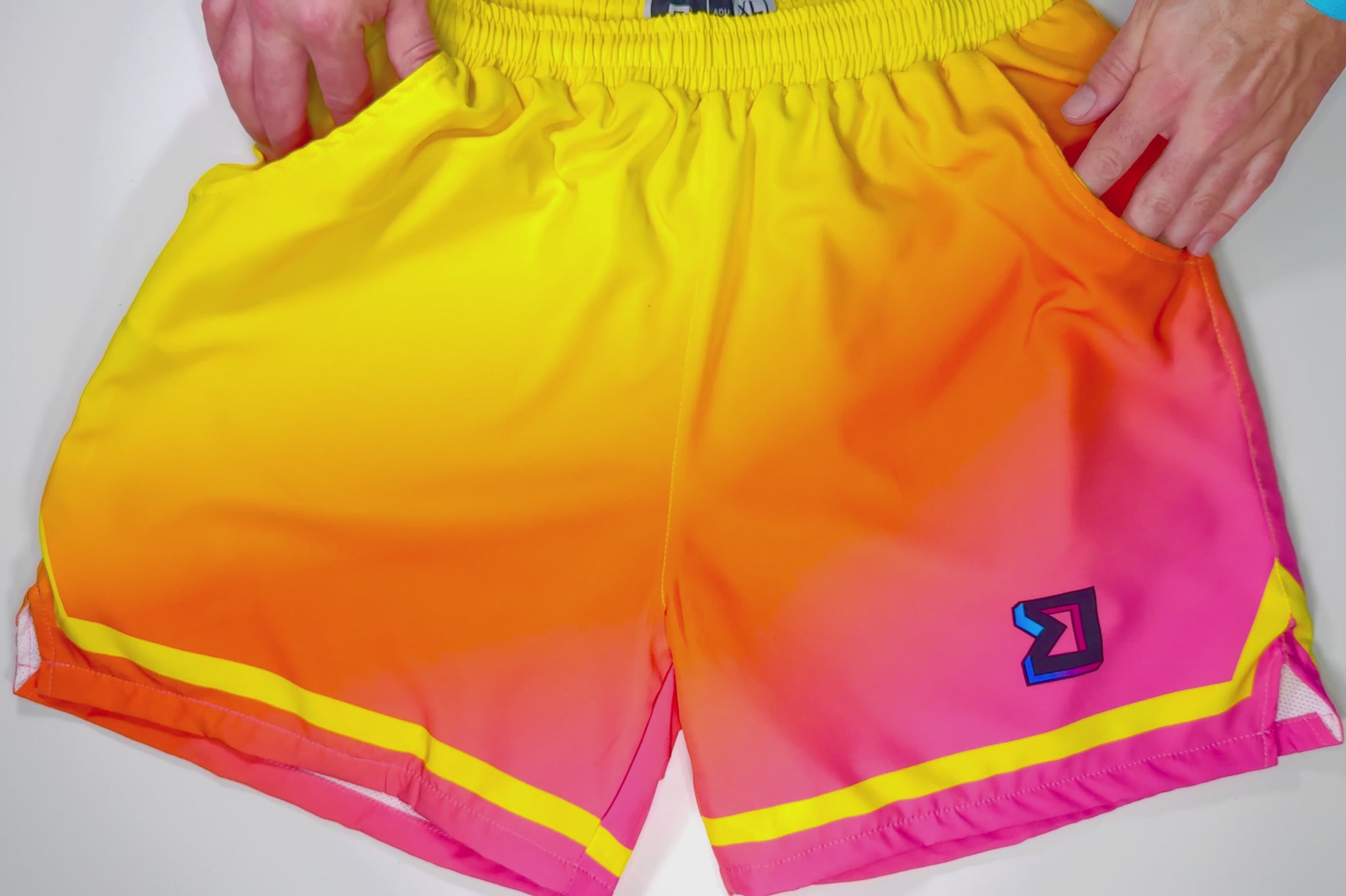 full video view of board style utility trap'n dry-fit shorts that can be worn in any different activities in a yellow to pink fade pattern with orange in the middle much like a sunset or sherbert