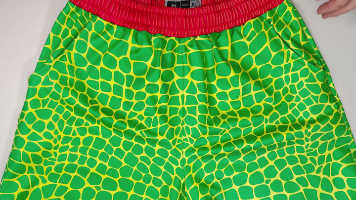 Trap Zombie Soft Quick-Dry basketball shorts in green reptile-scale pattern with red waistband, above-knee cut, and signature Trap’N Shorts logo.