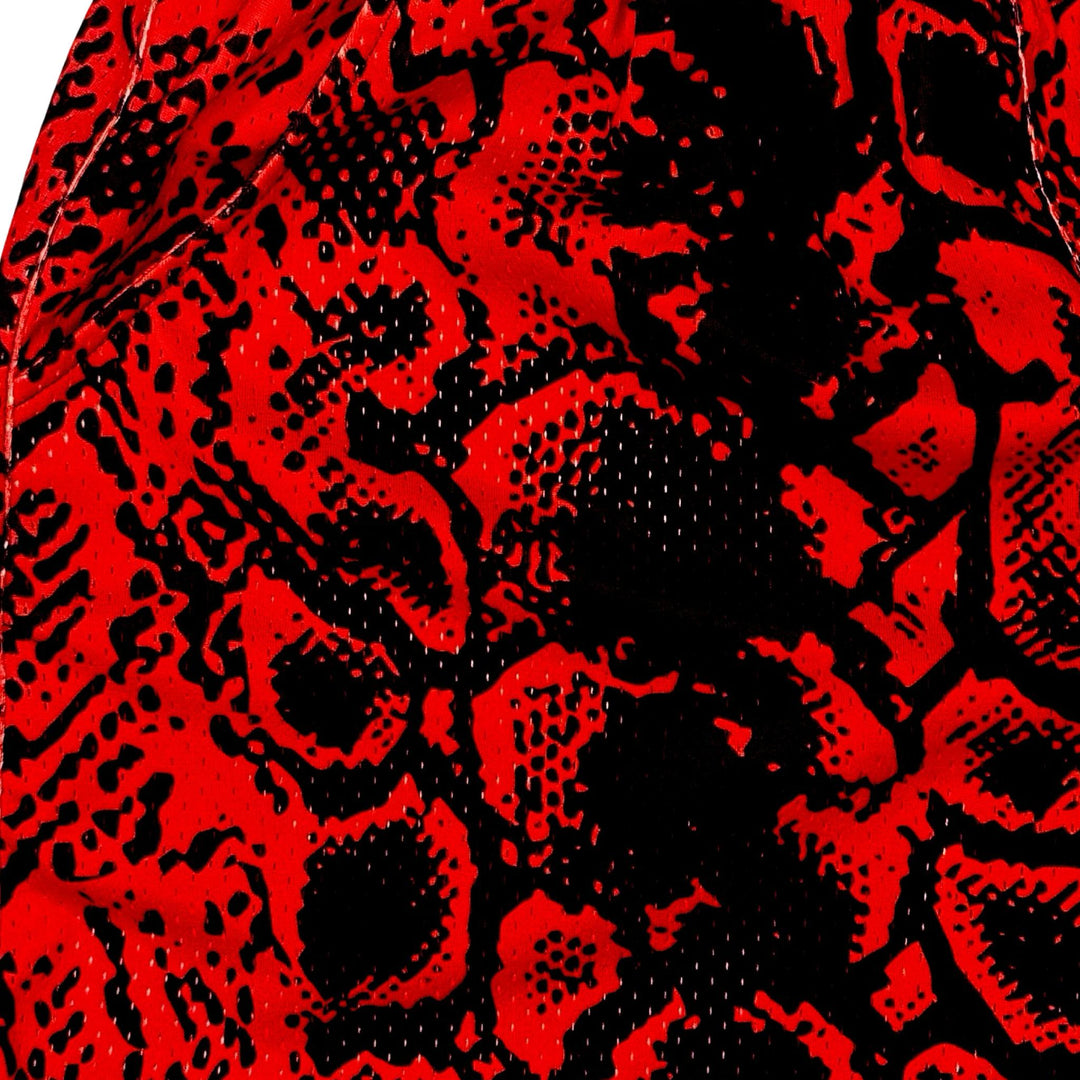 Red and black snakeskin patterned mesh shorts texture closeup