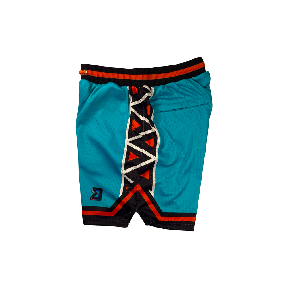 Trap Star Mesh Pro basketball shorts in aqua blue with tribal-style black/orange detailing, 2-inch pro waistband, and signature TR✶PN script by Trap’N Shorts.