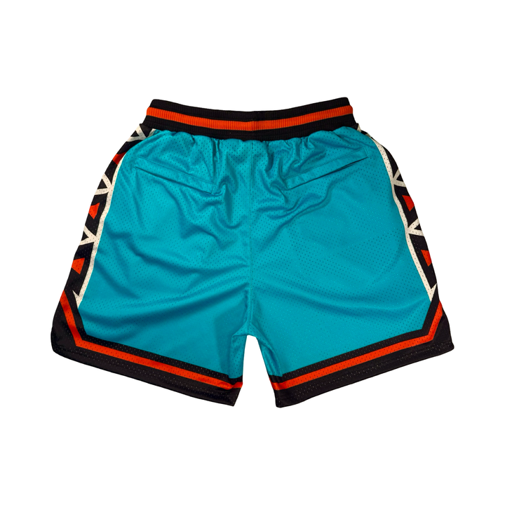 Trap Star Mesh Pro basketball shorts in aqua blue with tribal-style black/orange detailing, 2-inch pro waistband, and signature TR✶PN script by Trap’N Shorts.