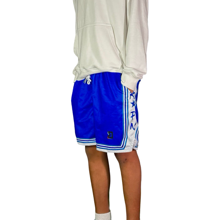 Person wearing blue shorts with white accents and a logo on a white background