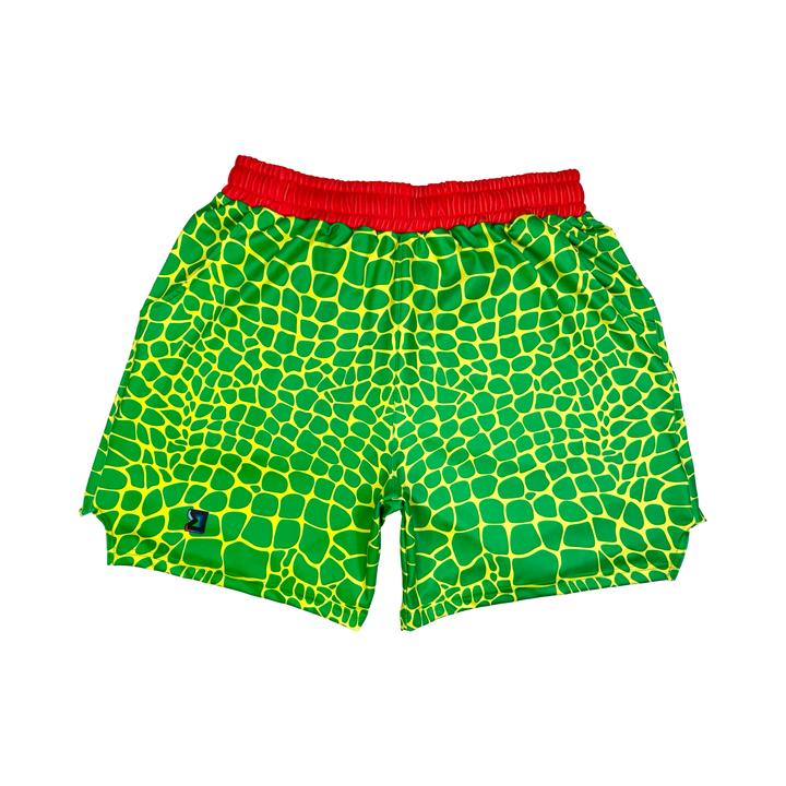 Trap Zombie Soft Quick-Dry basketball shorts in green reptile-scale pattern with red waistband, above-knee cut, and signature Trap’N Shorts logo.