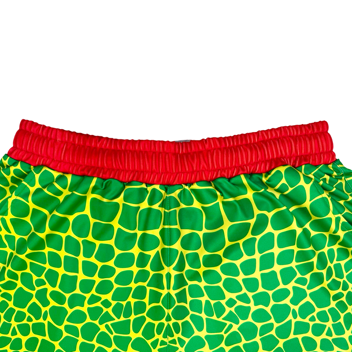 Trap Zombie Soft Quick-Dry basketball shorts in green reptile-scale pattern with red waistband, above-knee cut, and signature Trap’N Shorts logo.